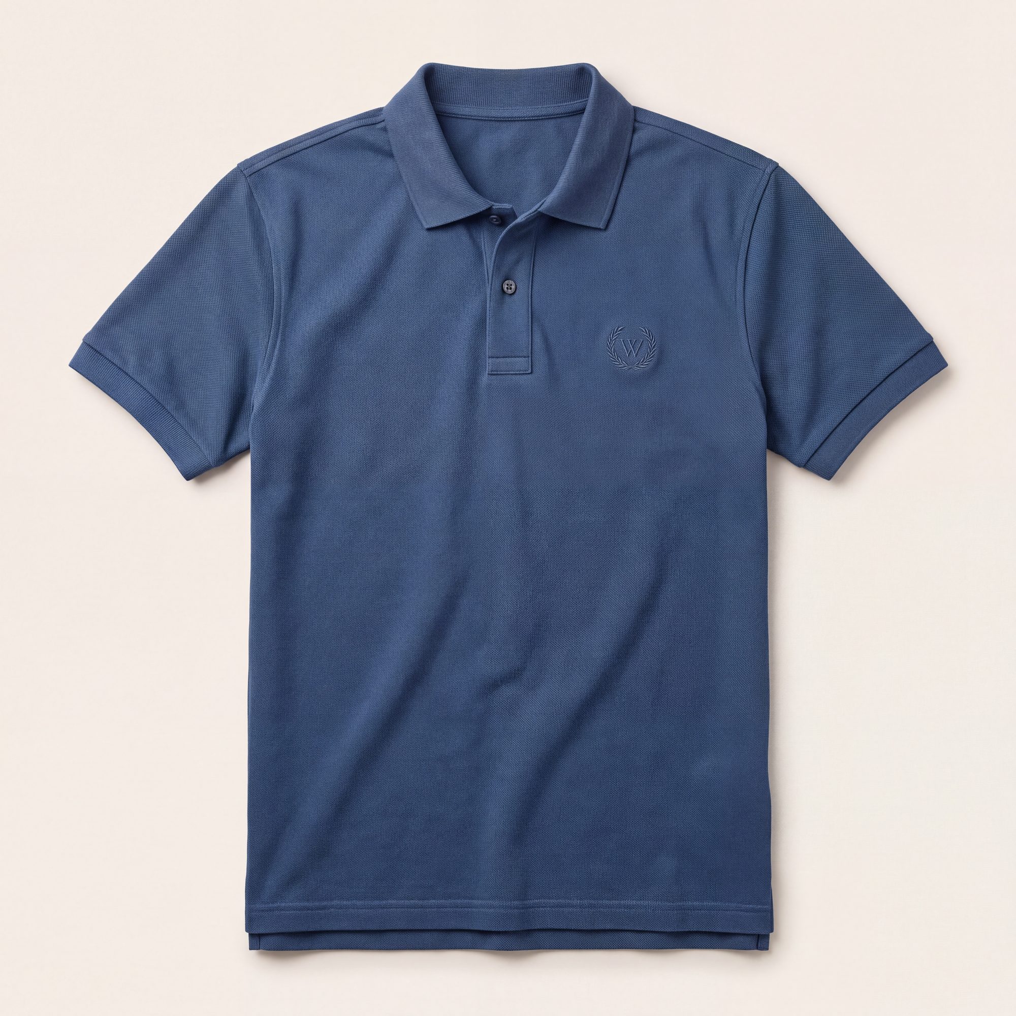 Blue pique polo with tonal embroidered emblem, laid flat